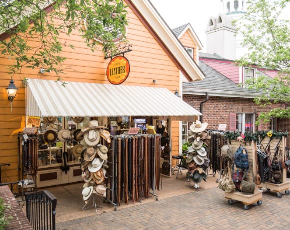 exterior of Sunrise Leatherworks with hats, belts, and purses for sale outside