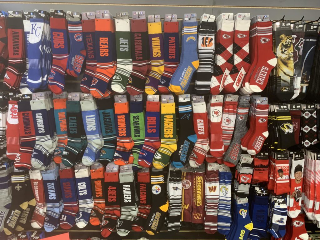 assortment of sports team branded socks hanging on display
